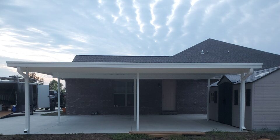 Insulated aluminum carport cover protecting a vehicle from sun and rain